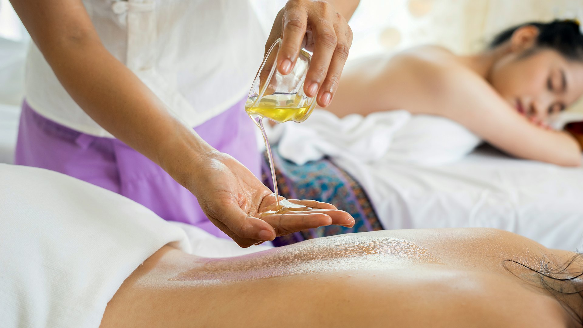 Registered massage therapist applying massage oil
